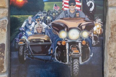 a mural of several people on motorcycles on display at Amherst Patriots Park